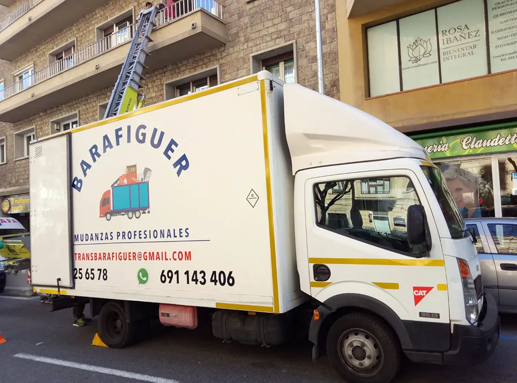 Camión rotulado de Mudanzas Barafiguer aparcado junto a una plataforma elevadora