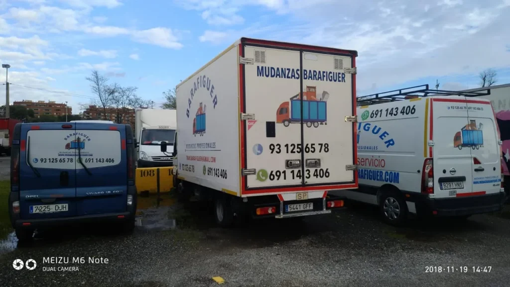 Camión y furgonetas rotulados de Mudanzas Barafiguer aparcados