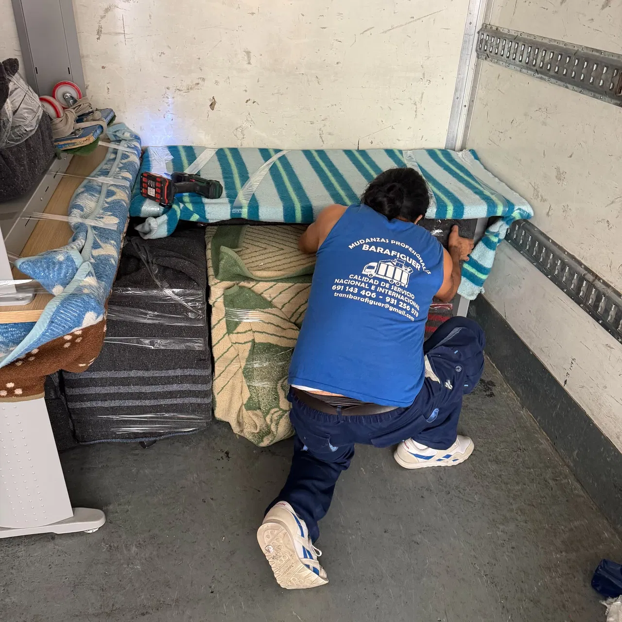 Operario de Mudanzas Barafiguer protegiendo un colchón antes de bajarlo por la escalera