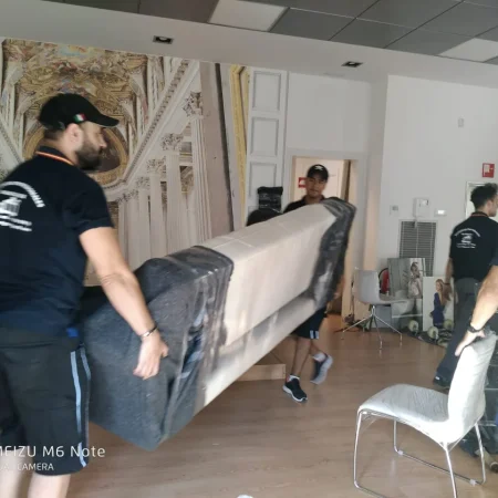 Operarios de Mudanzas Barafiguer trasladando un mueble embalado dentro de un local