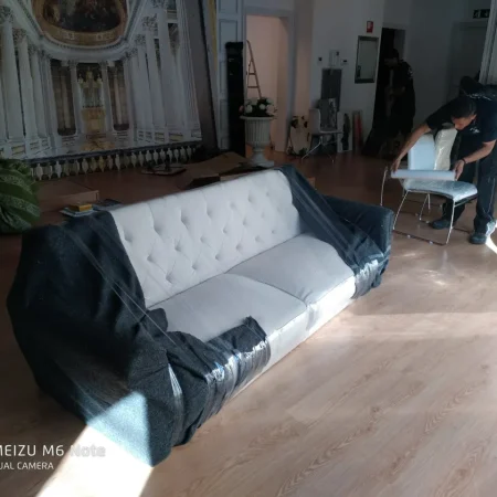 Sofá blanco cubierto con funda protectora antes de una mudanza en Barcelona