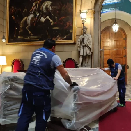 Operarios de Mudanzas Barafiguer descubriendo una escultura en una sala noble