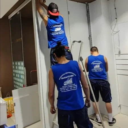Operarios de Mudanzas Barafiguer desmontando un armario de puertas correderas